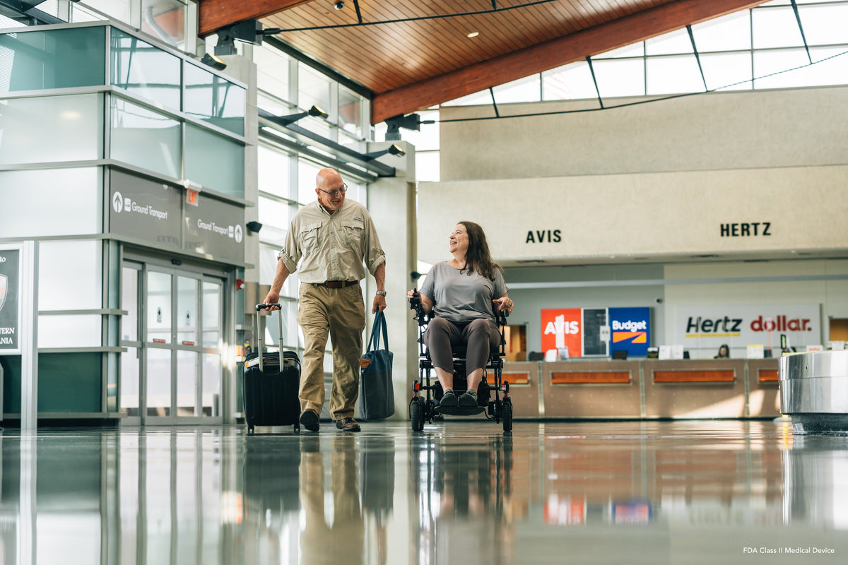 Pride Jazzy Carbon power wheelchair, lifestyle - person using chair in airport terminal